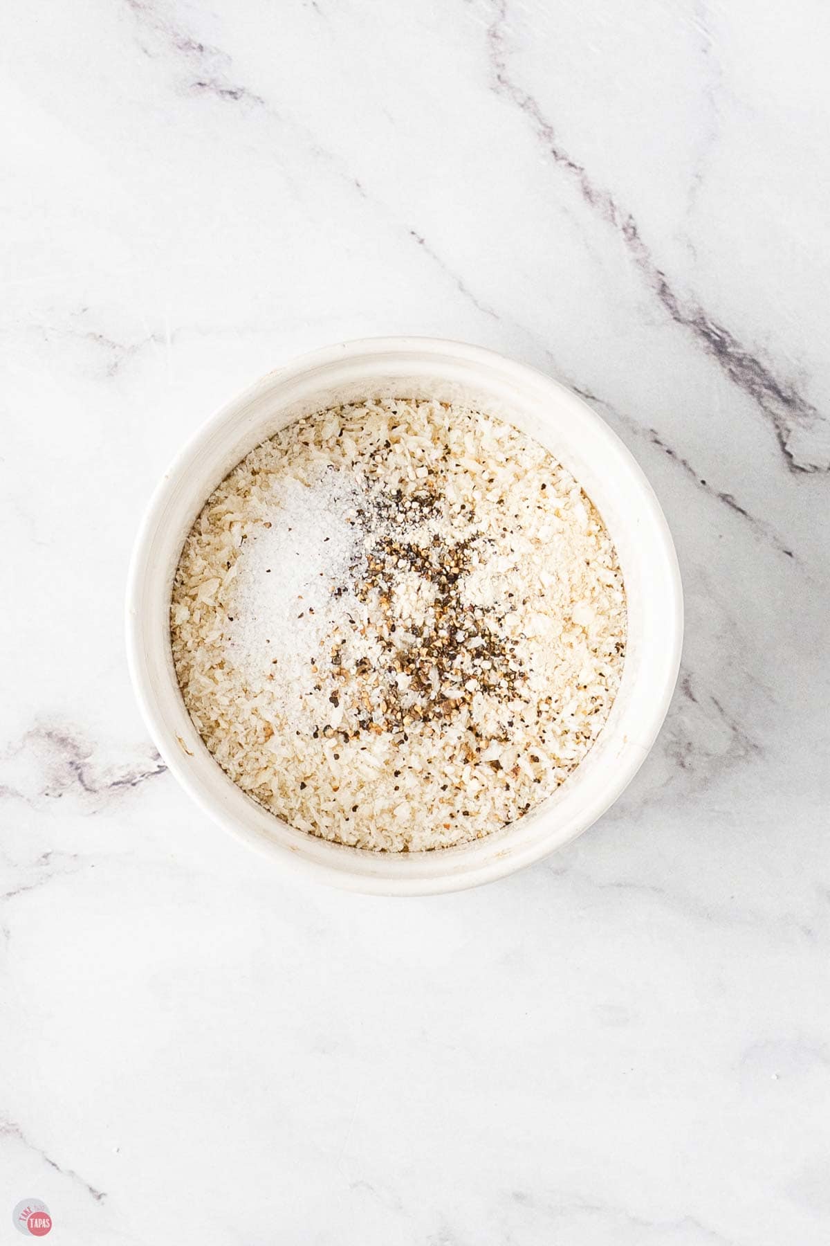 seasoned flour in a white mixing bowl