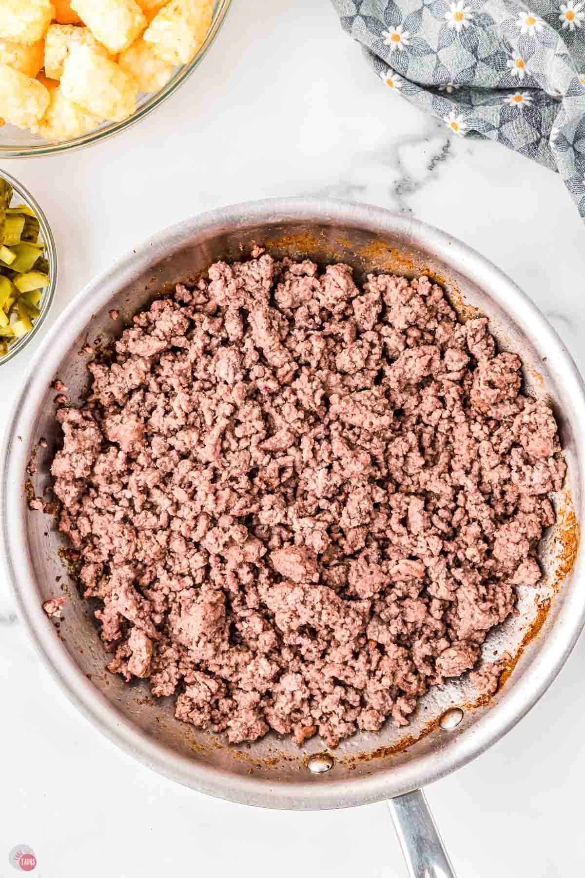 cooked ground beef in a silver skillet
