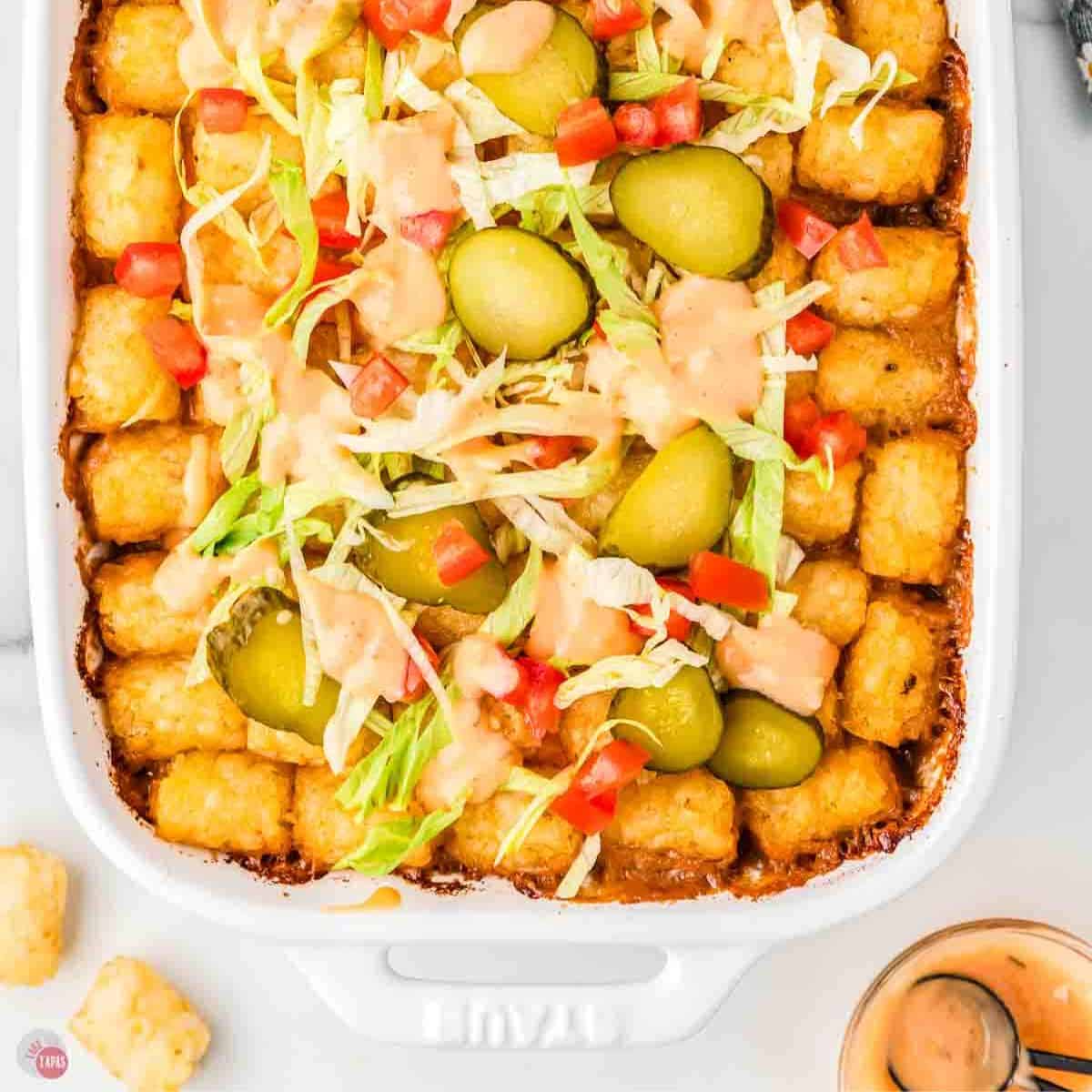 close up of big mac casserole with tater tots in a white baking dish