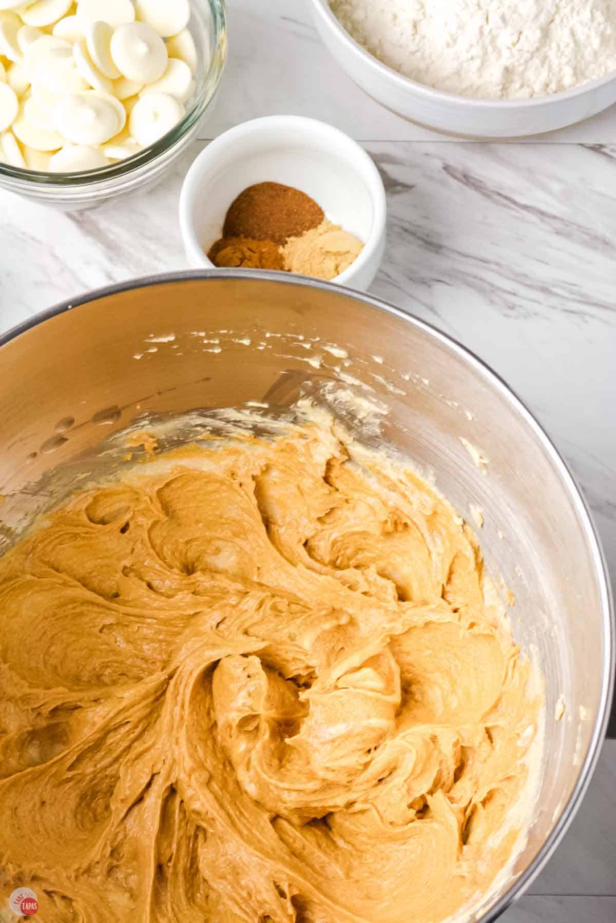 cookie dough being combined in a steel mixing bowl