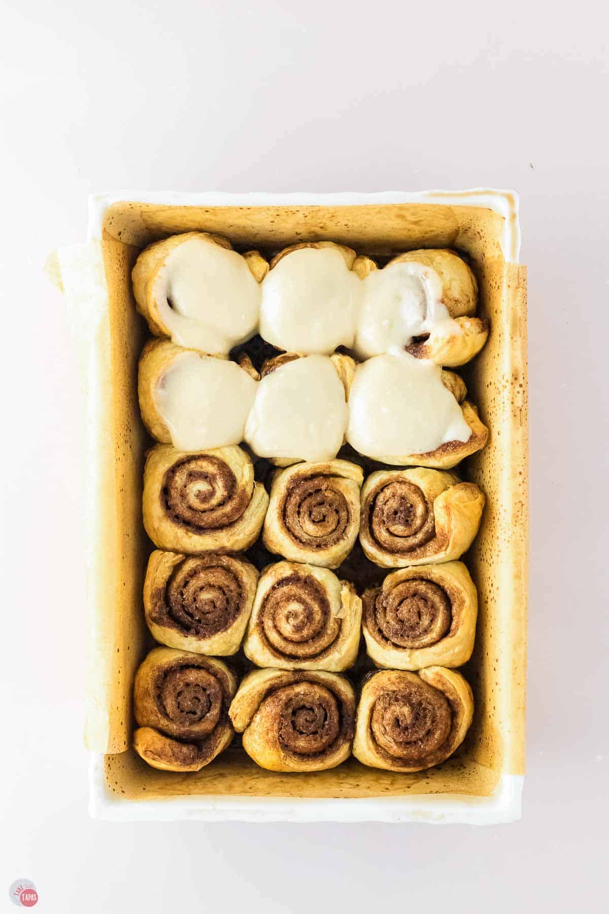 baked cinnamon rolls, partially frosted