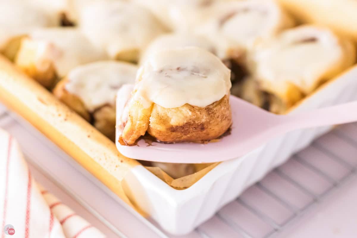 spatula holding a cinnamon roll on it