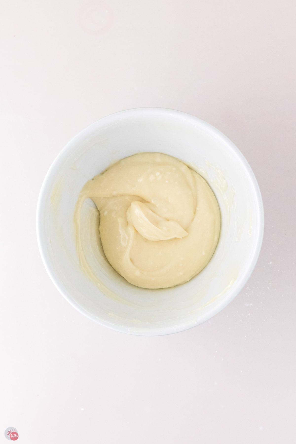 cream cheese frosting in a small white bowl