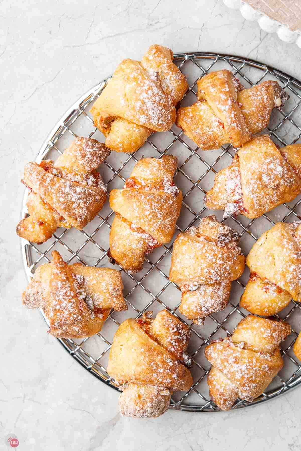 wire cooling rack topped with rugelach cookies dusted with powdered sugar