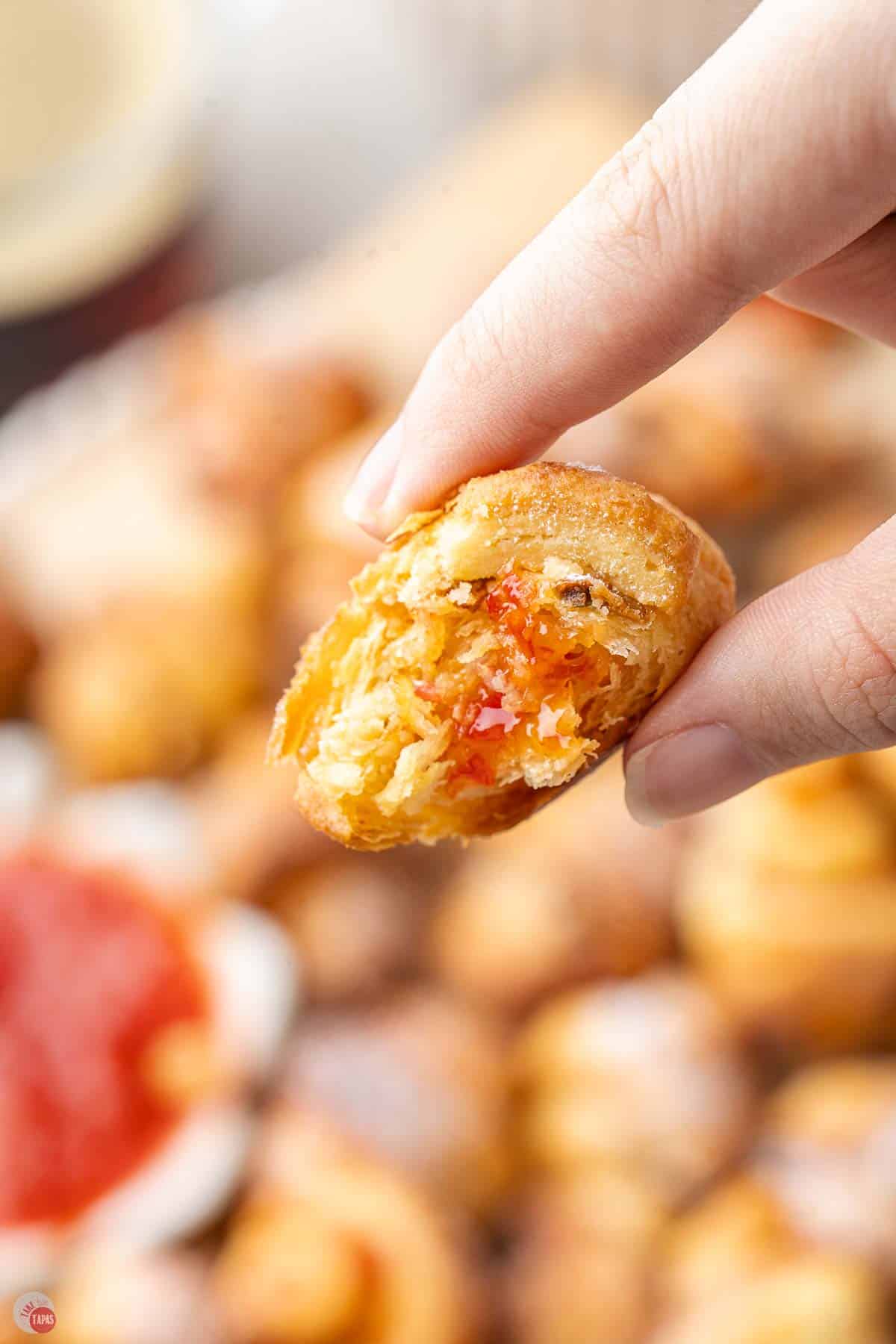 hand holding a rugelach cookie with a bite removed