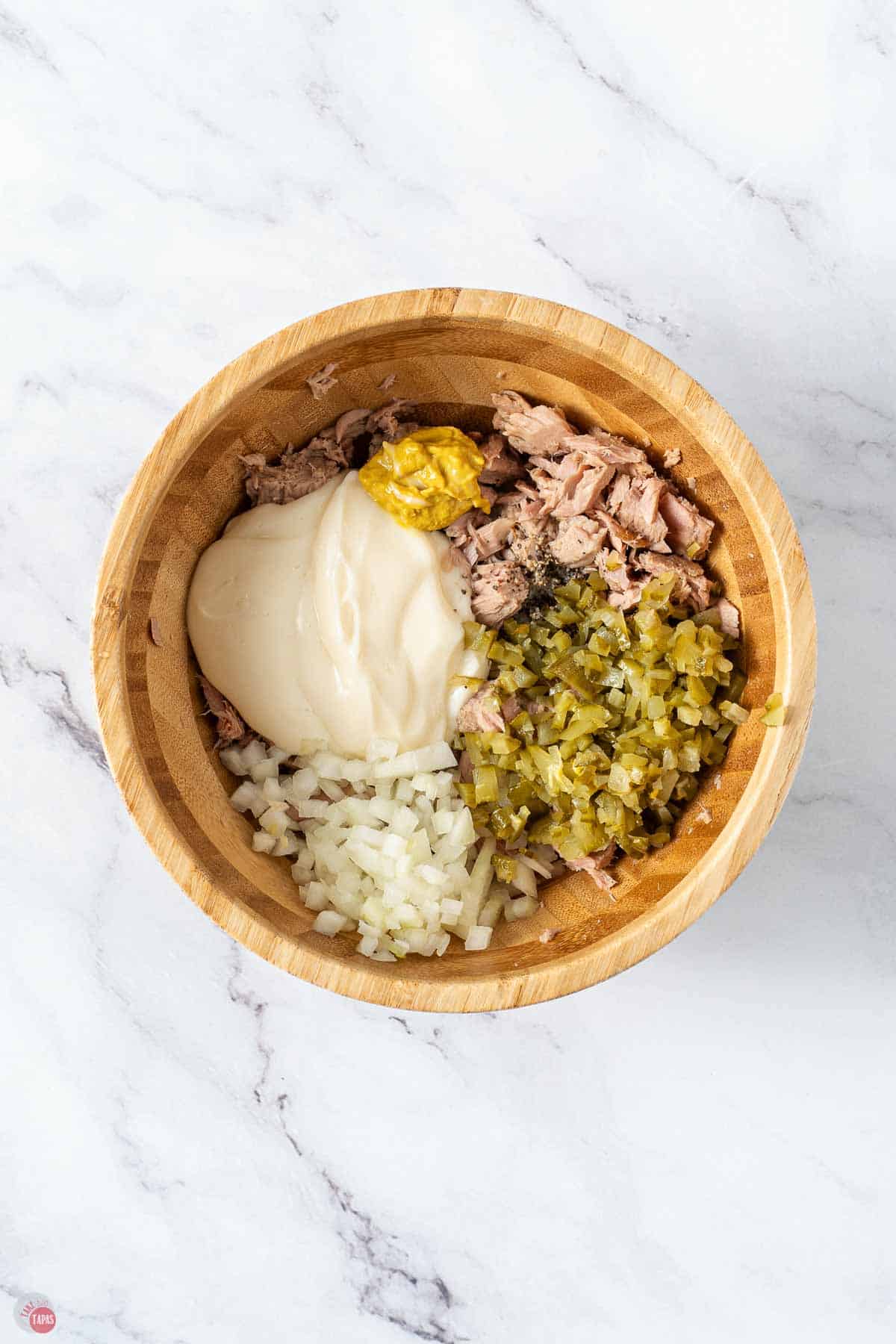 brown mixing bowl with canned tuna, mayo, mustard, and spices