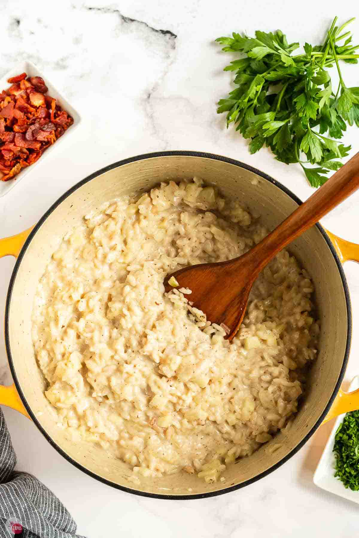 Creamy apple risotto stirred with a wooden spoon
