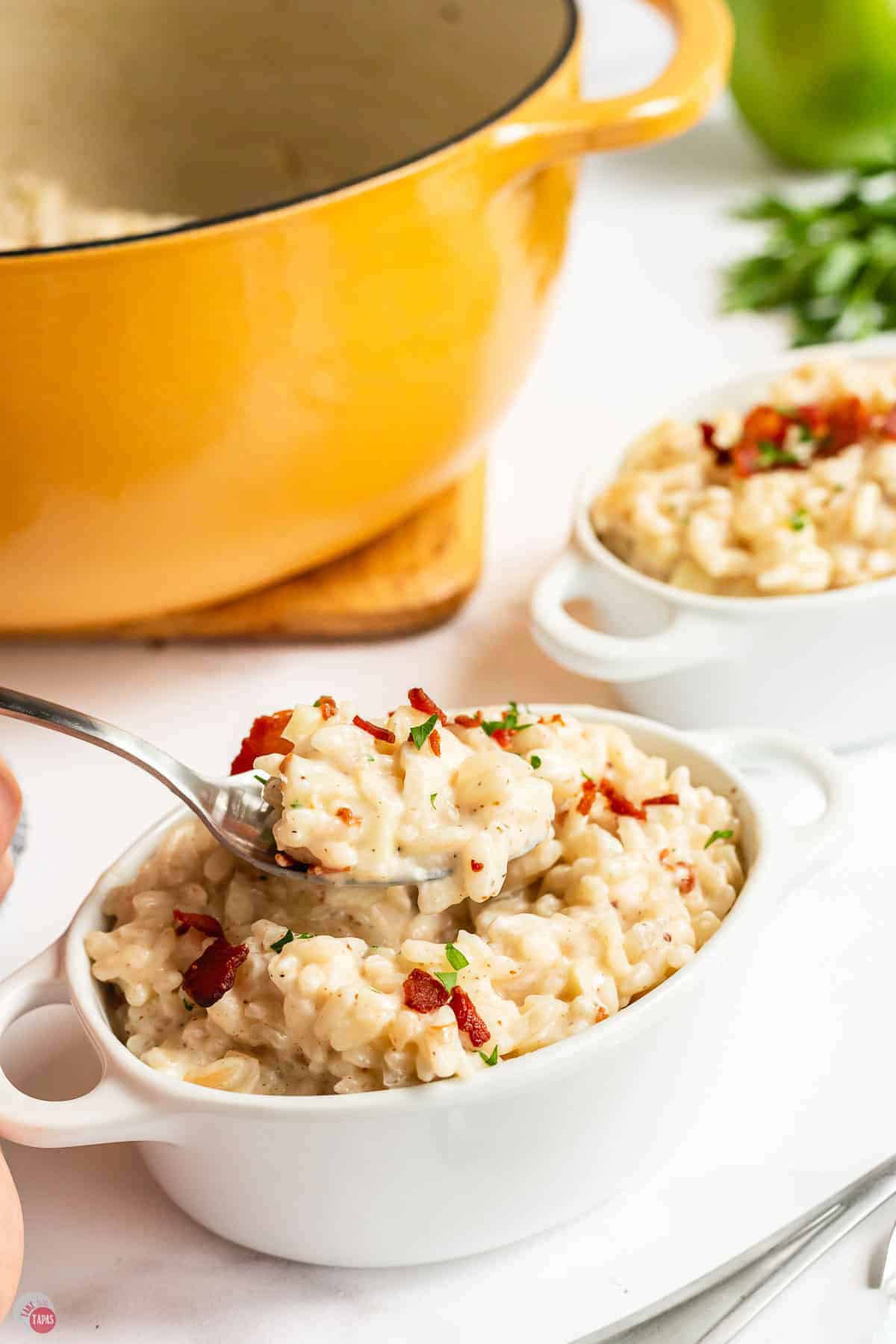 Spoon in a bowl of apple risotto with bacon