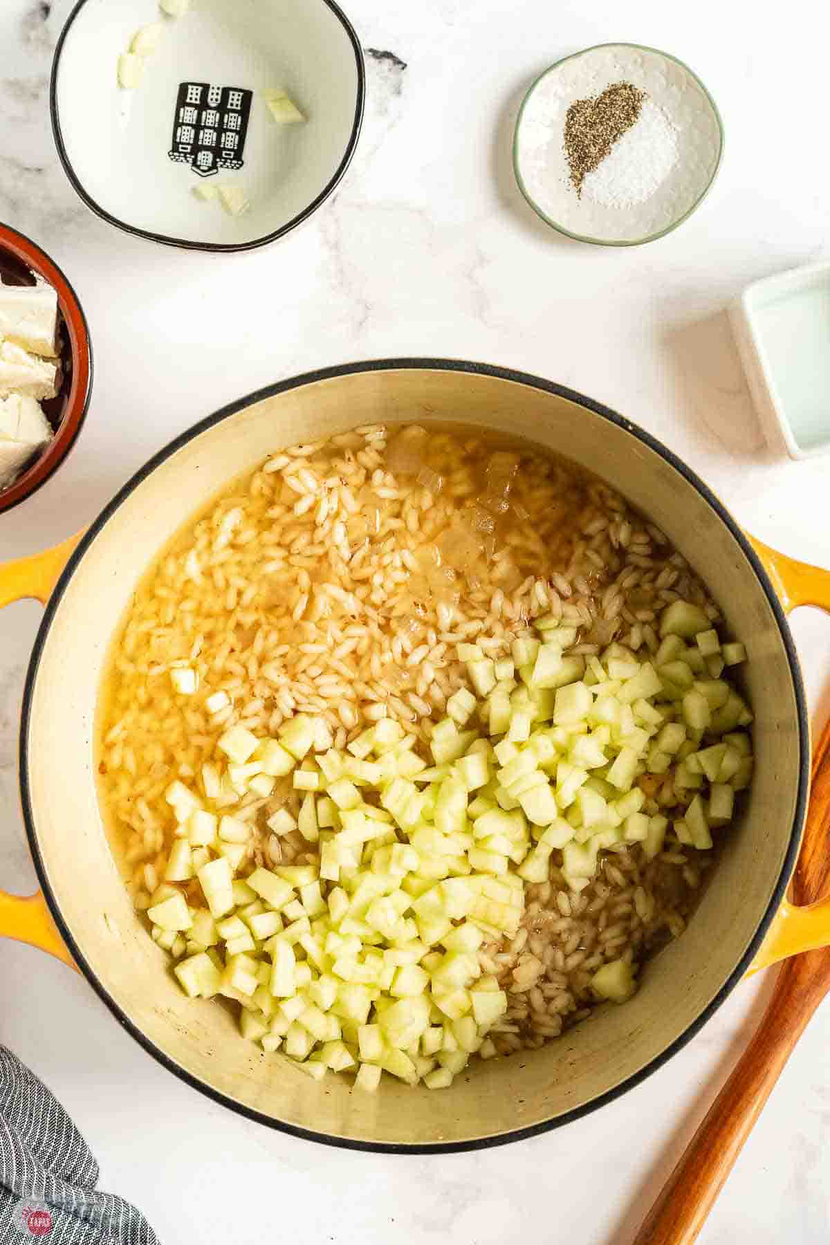 Diced apples and stock added to the risotto in the pot