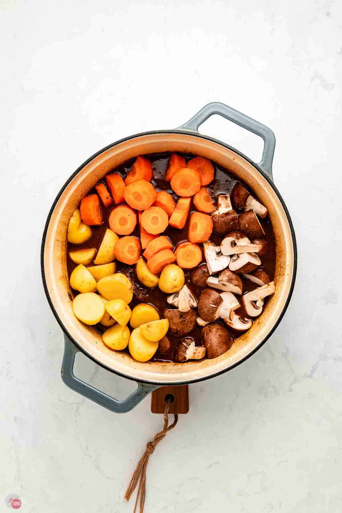 stew pot with carrots, potatoes, and mushrooms
