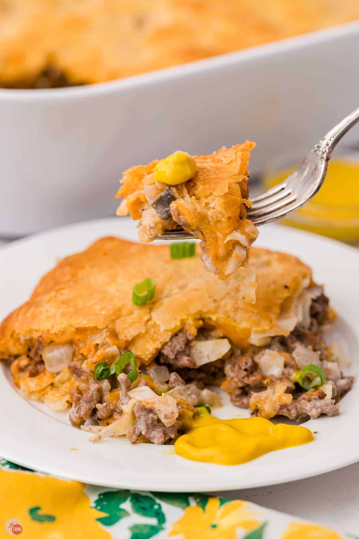 fork with bite of casserole hovering over a plate