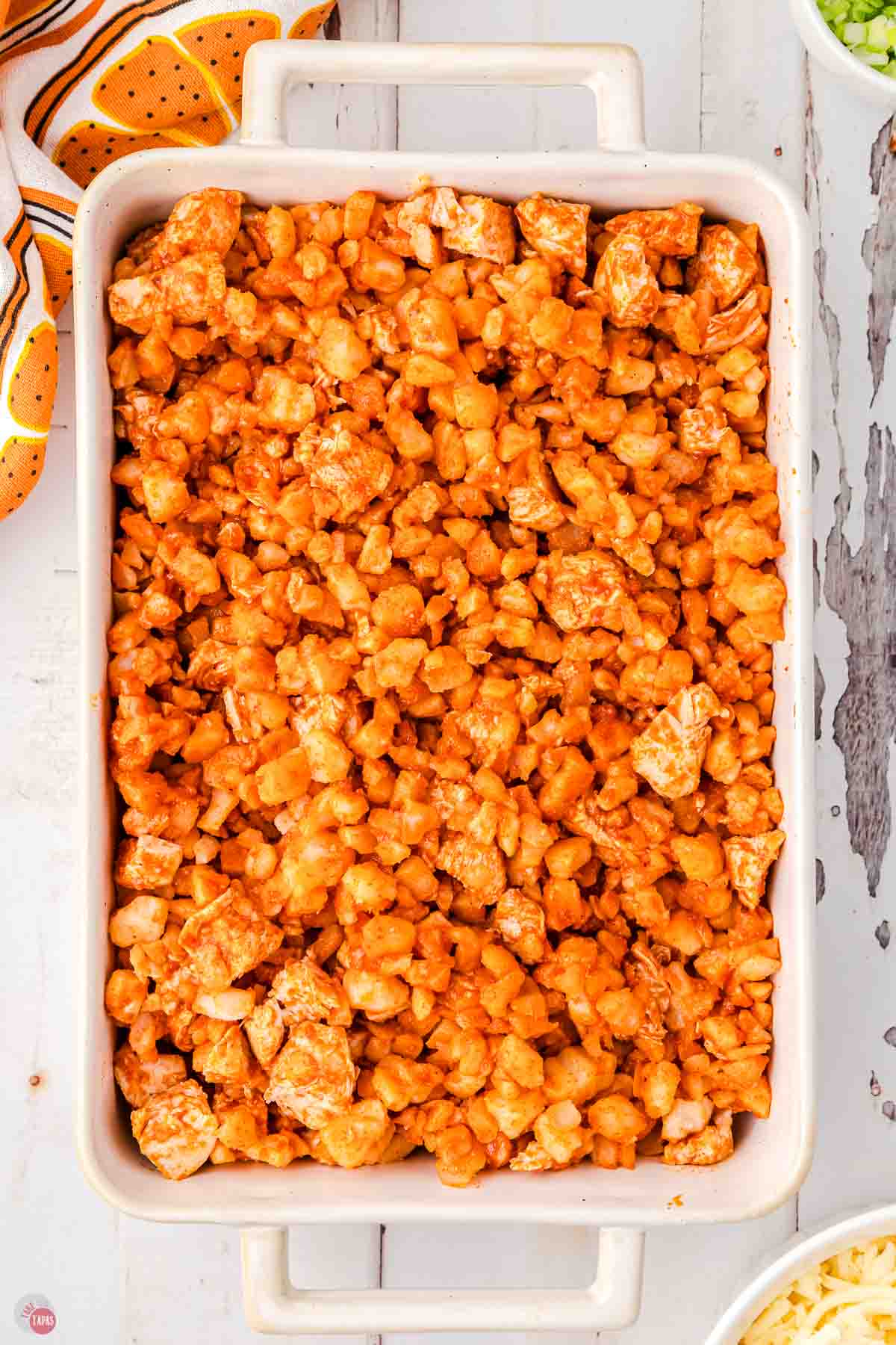 buffalo chicken and potatoes in a white casserole dish
