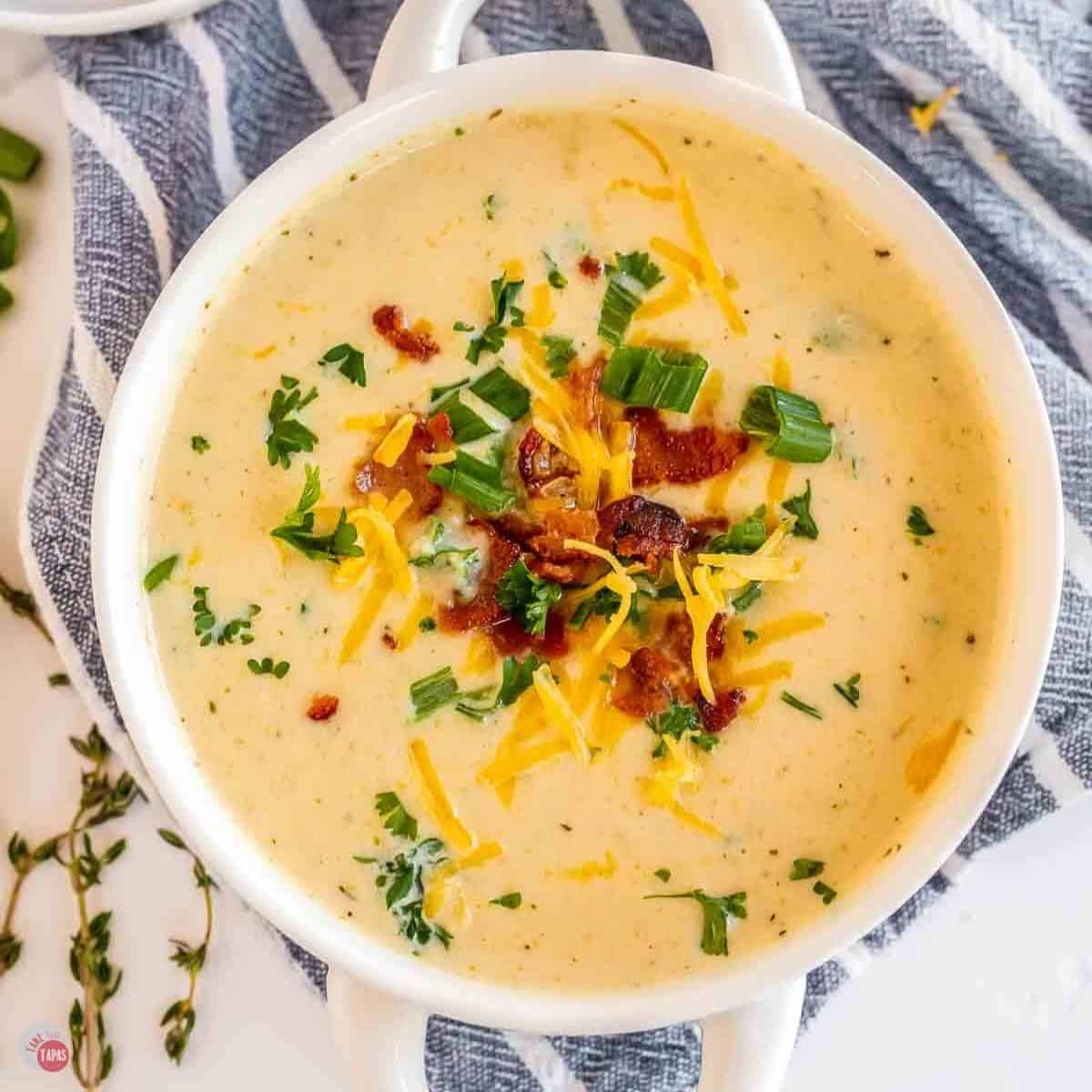 bowl of cauliflower cheese soup topped with bacon and green onions