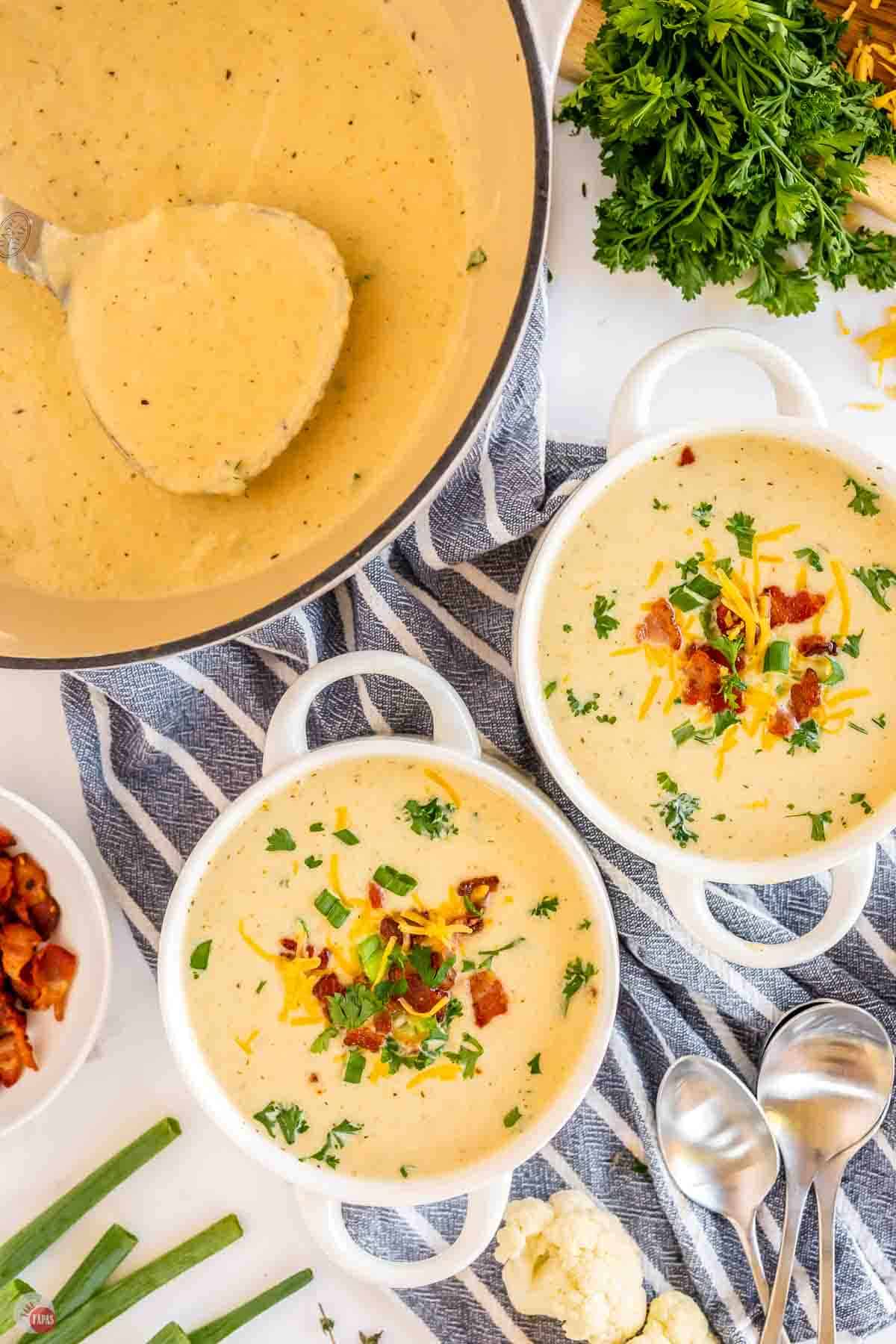 two bowls of soup on a blue and white striped napkin