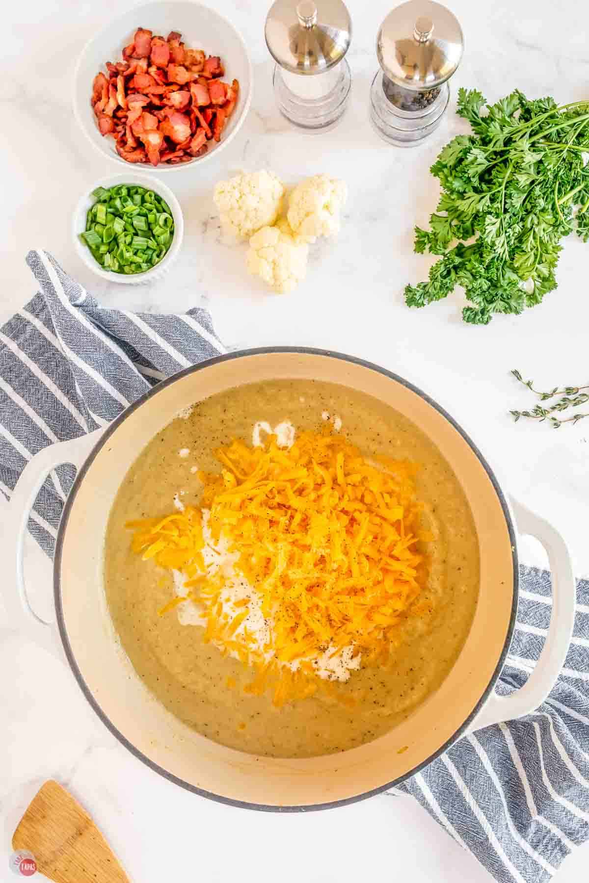 pot of soup with shredded cheese and cream on top