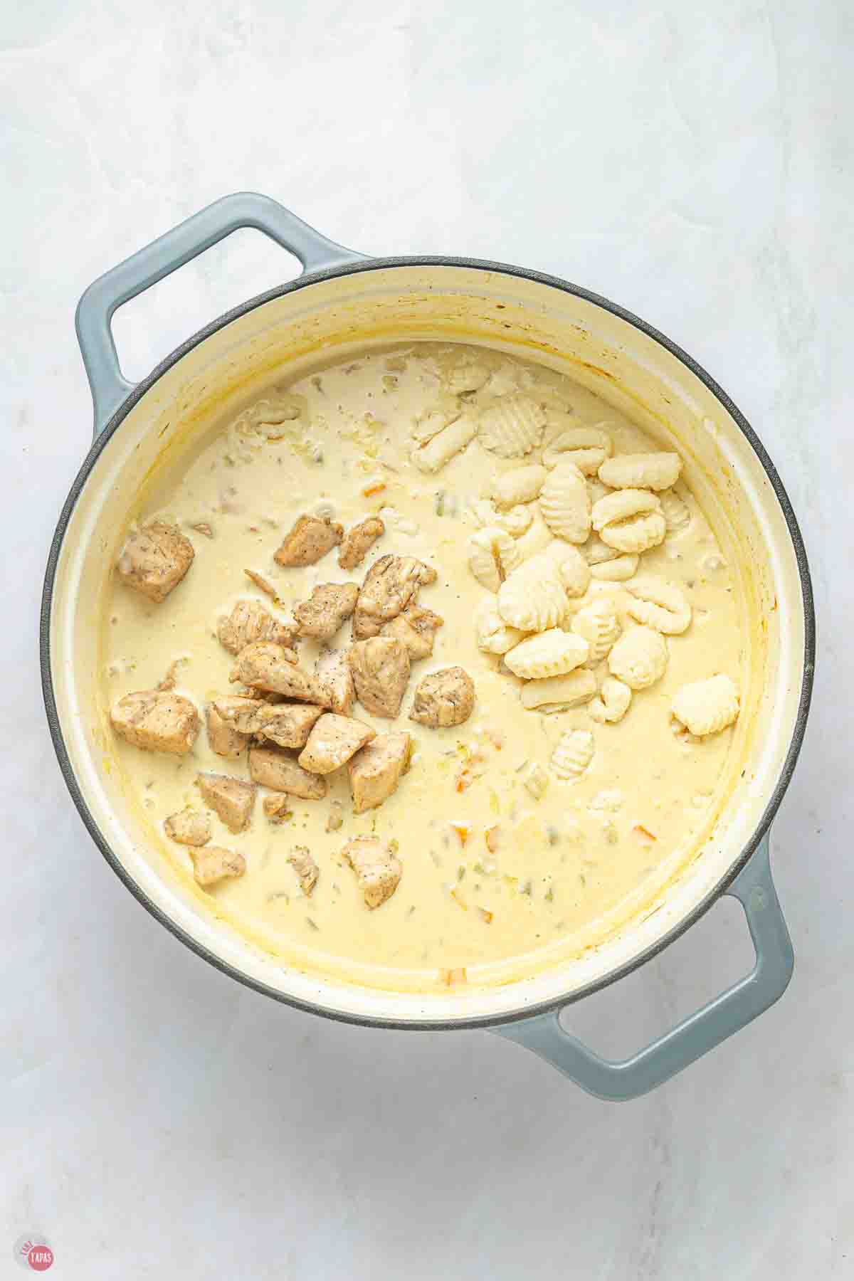 chicken and gnocchi added to a soup pot