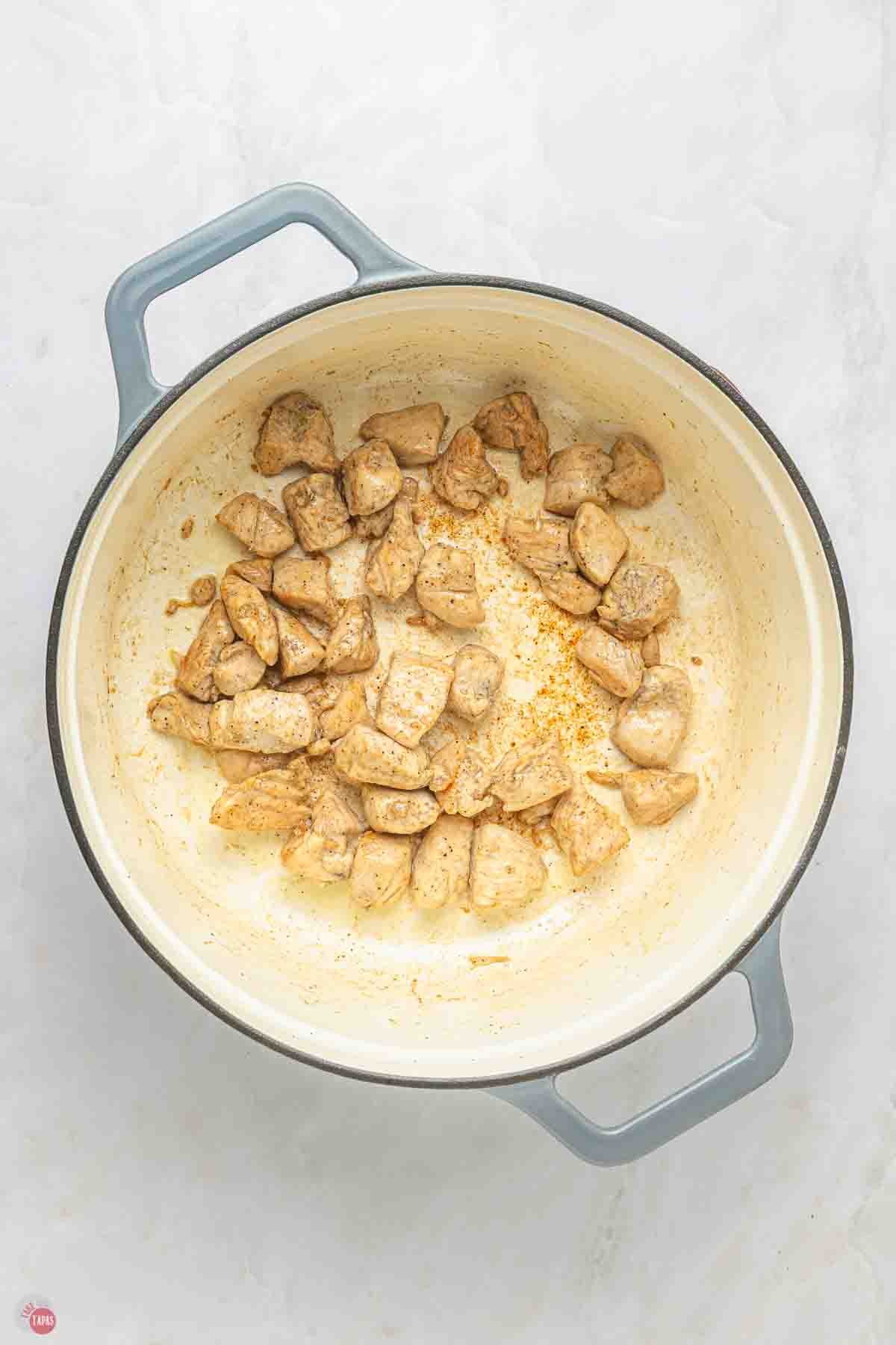 diced chicken breast cooking in a grey pot