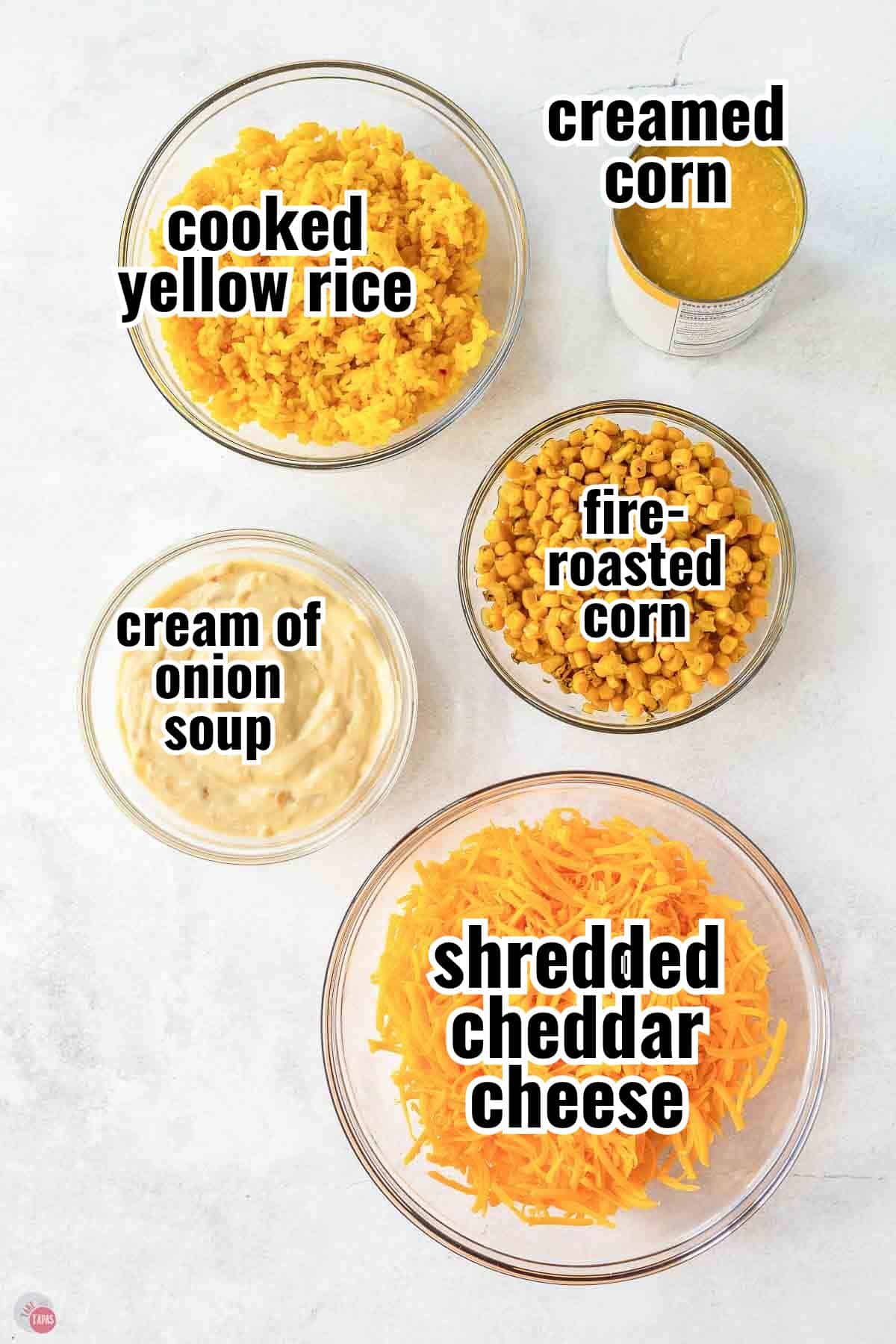 Labeled bowls of yellow rice, fire roasted corn, cream of onion soup and shredded cheddar cheese for corn and rice casserole