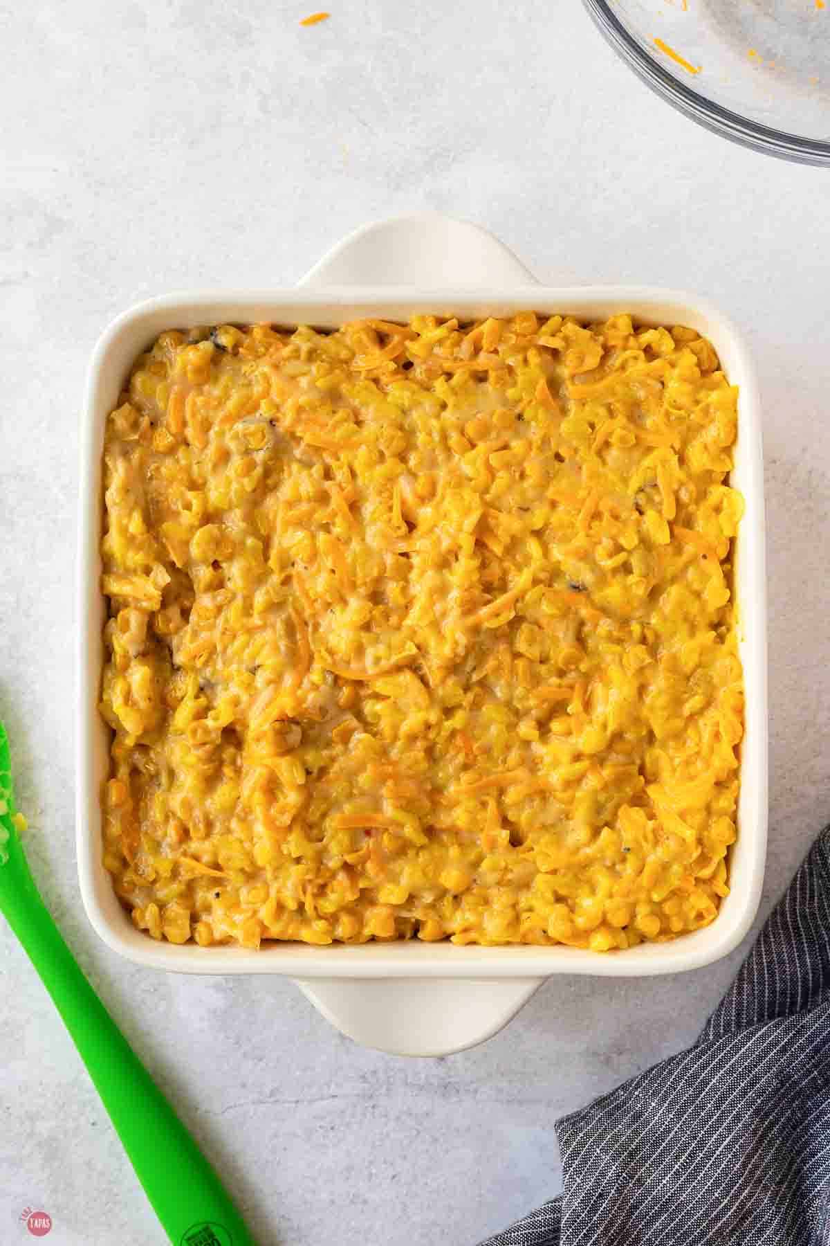 Unbaked corn and rice casserole spread in a white baking dish