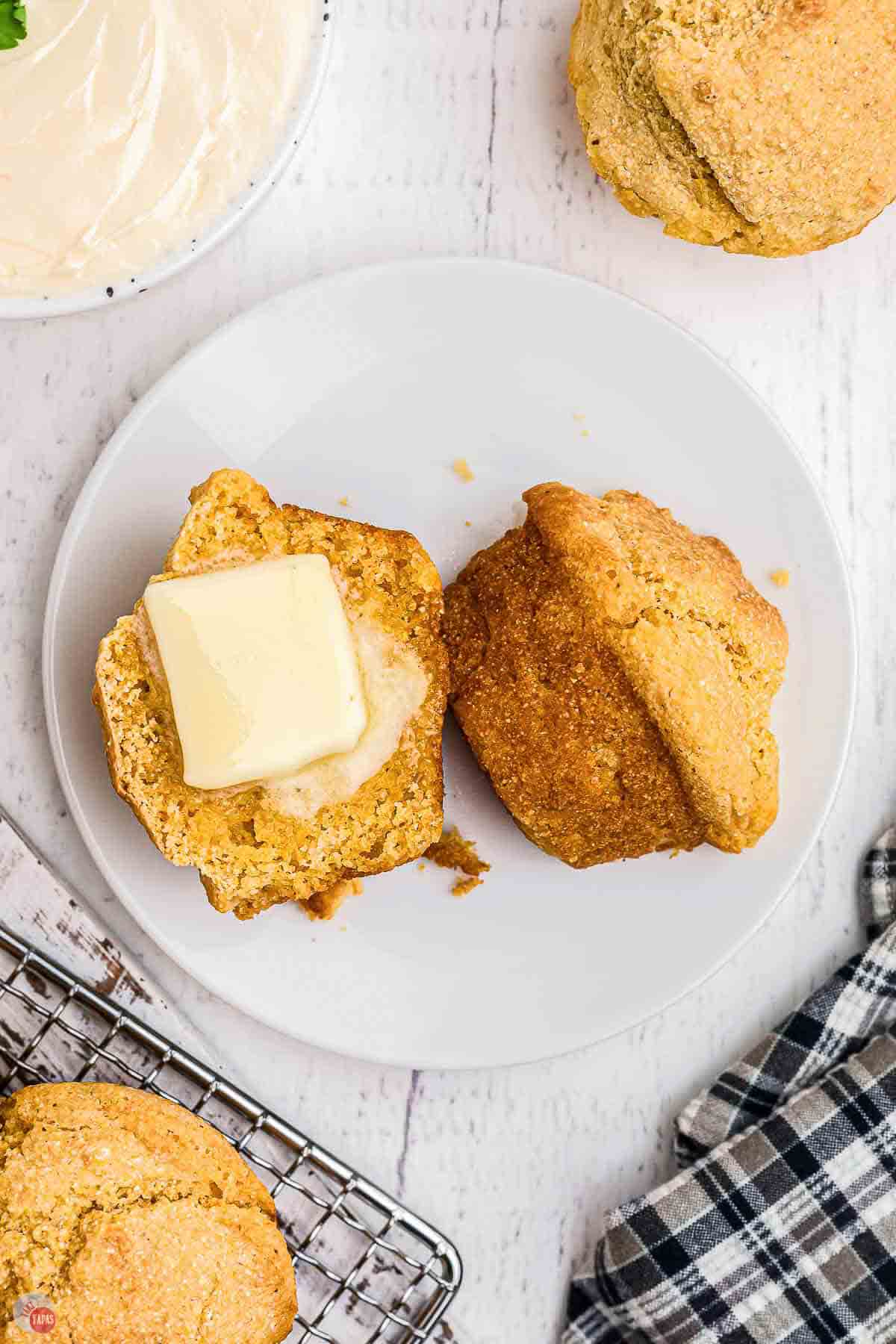 cornbread muffin cut in half with a pat of butter melting on one side