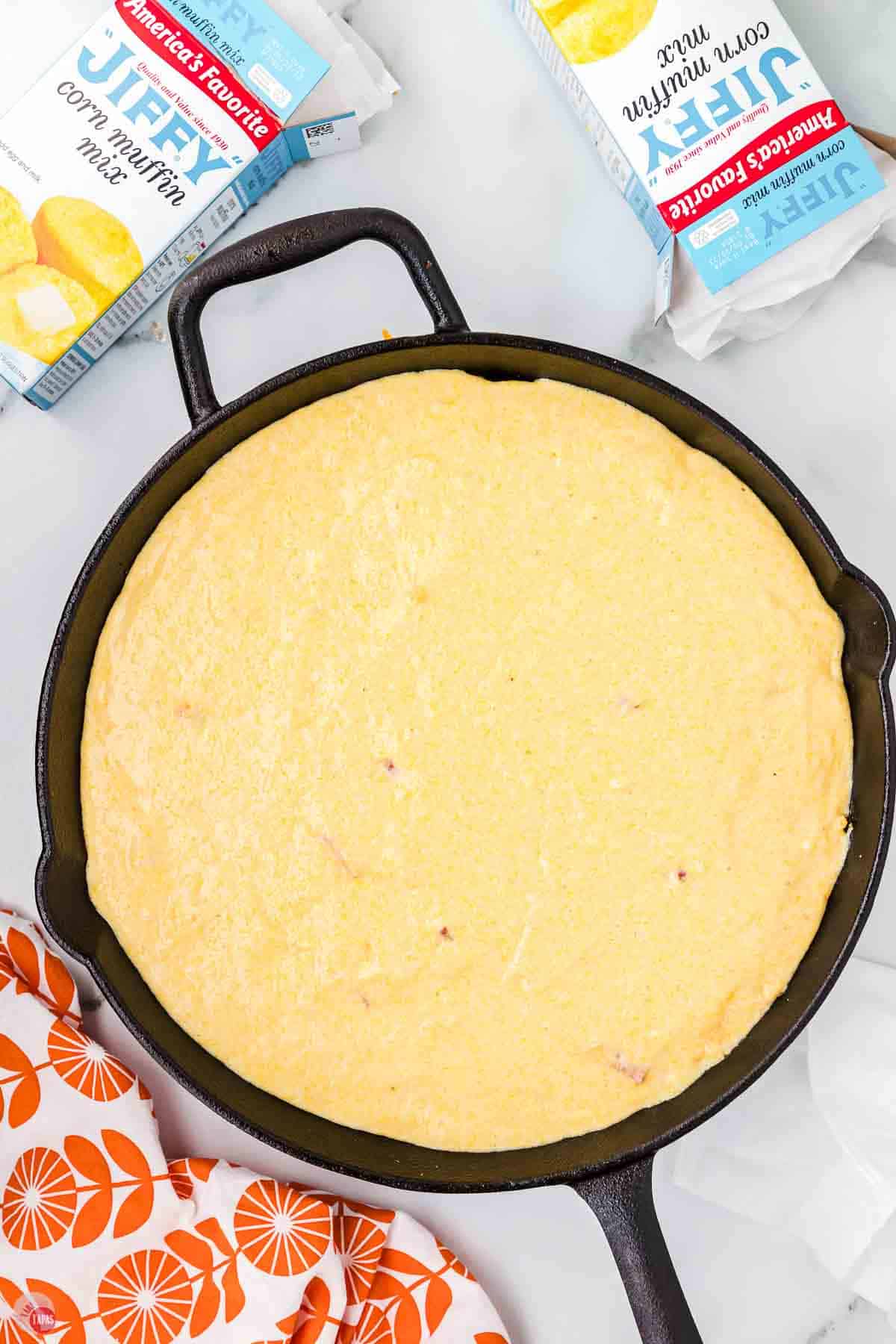 iron skillet filled with casserole and topped with cornbread batter