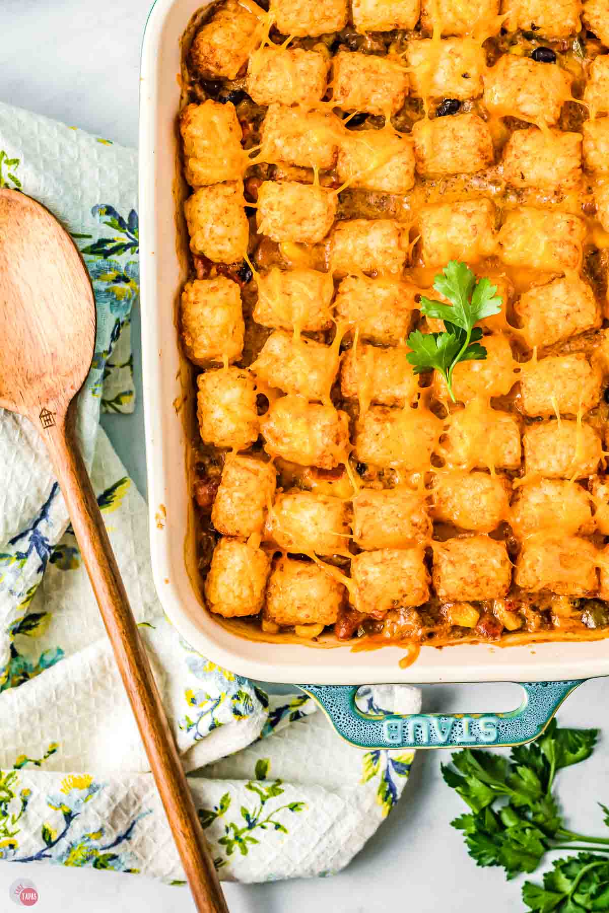 casserole dish with tater tots and a large spoon