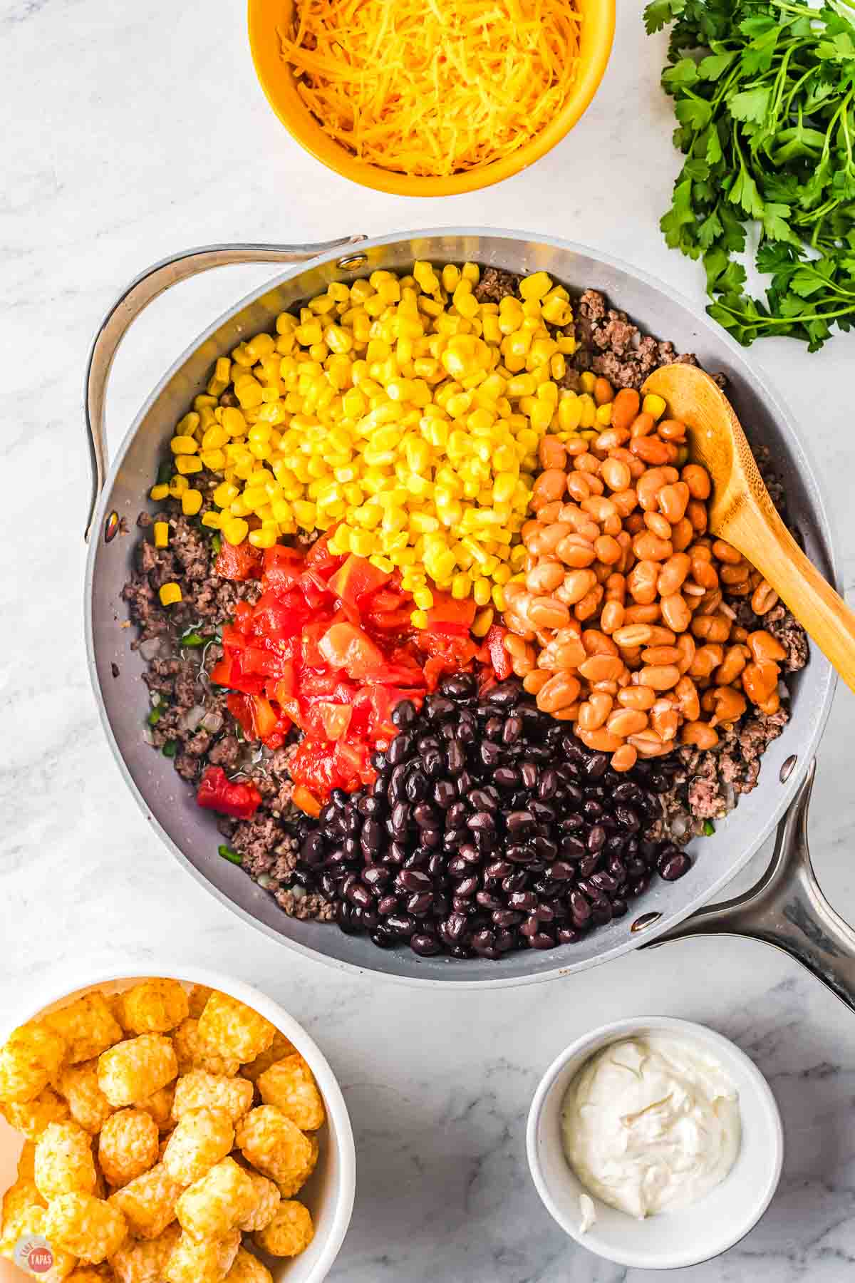 skillet with cooked ground beef, beans, and corn in it