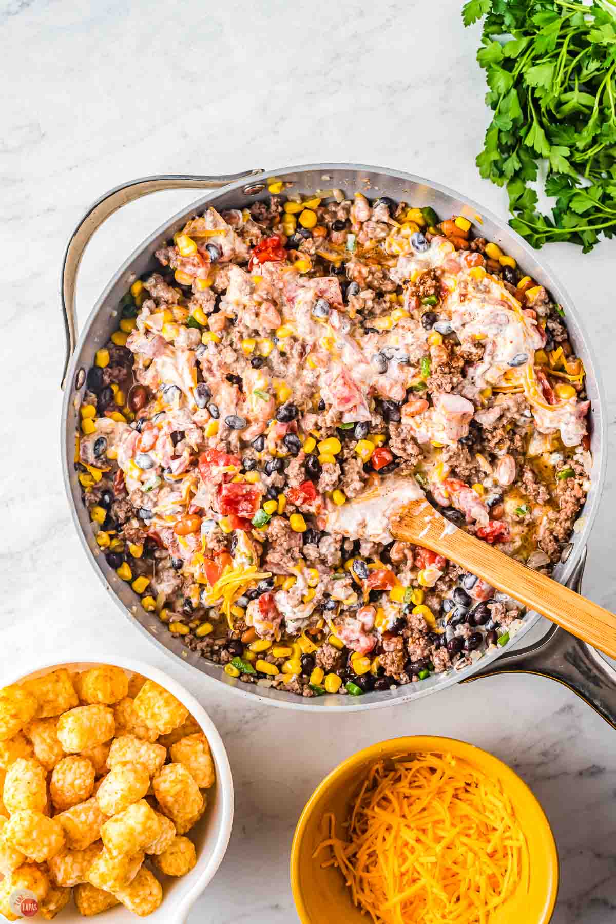beef, bean, and sour cream mixing in a skillet