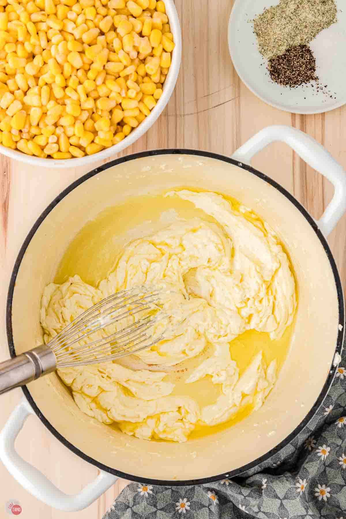 white pot with cream cheese and butter being whisked together