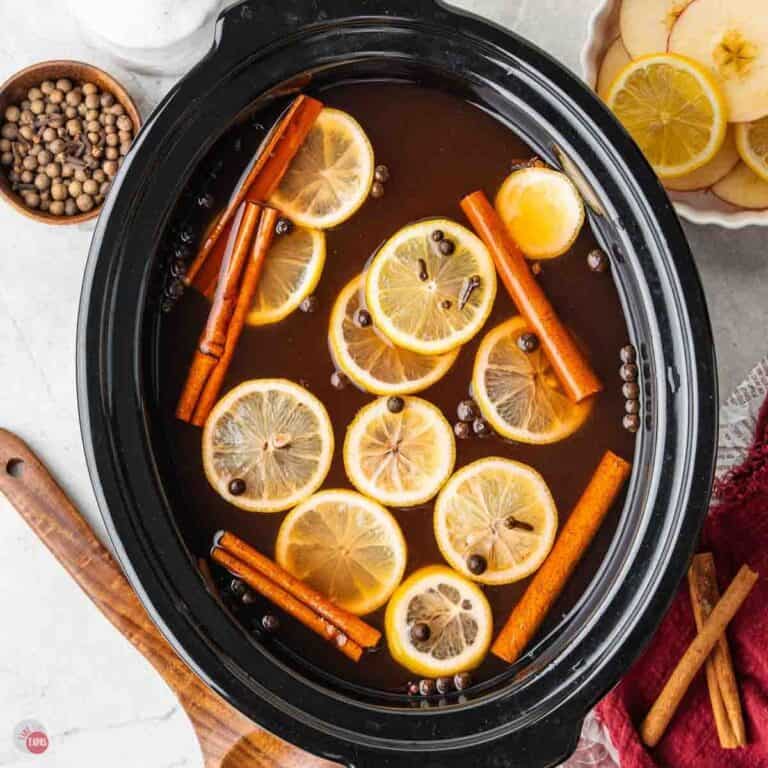 crockpot filled with wassail punch and lemon slices