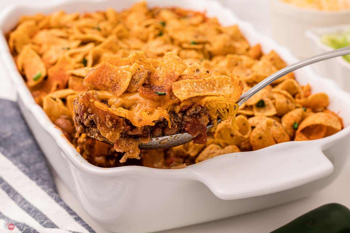 spoon scooping frito casserole out of a dish