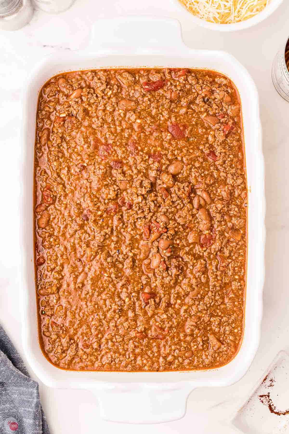 ground beef and sauce mixture in a white rectangle casserole dish