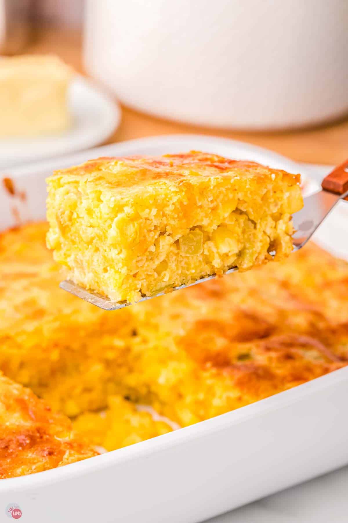cornbread casserole with chopped green chilies being scooped out with a spatula
