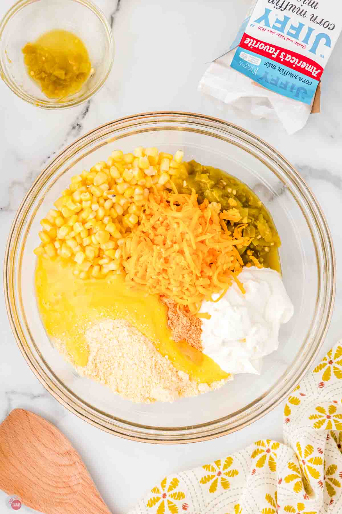 corn, butter, cheese, sour cream, and chilies in a clear bowl