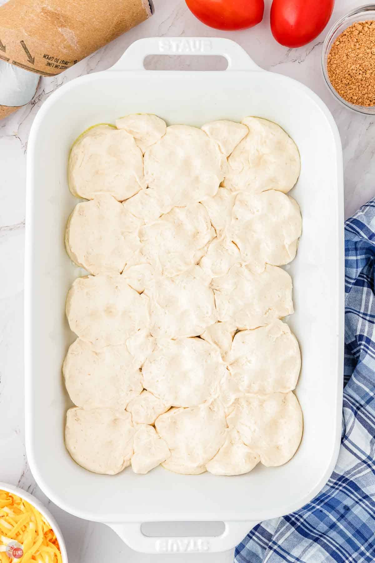 biscuits layered in the bottom of a baking dish