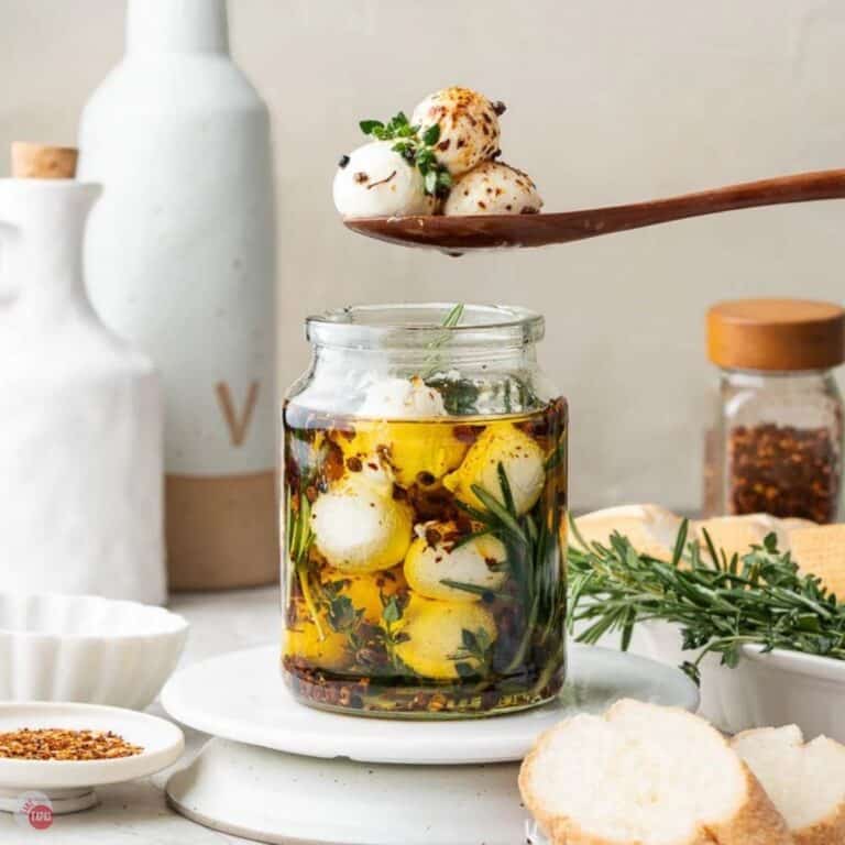 jar of marinated mozzarella balls with a spoon scooping a few out
