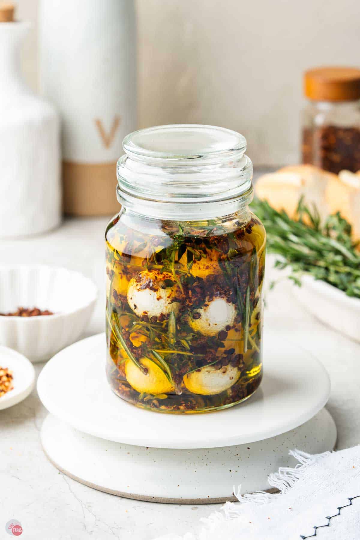 jar of marinated mozzarella balls with olive oil and herbs