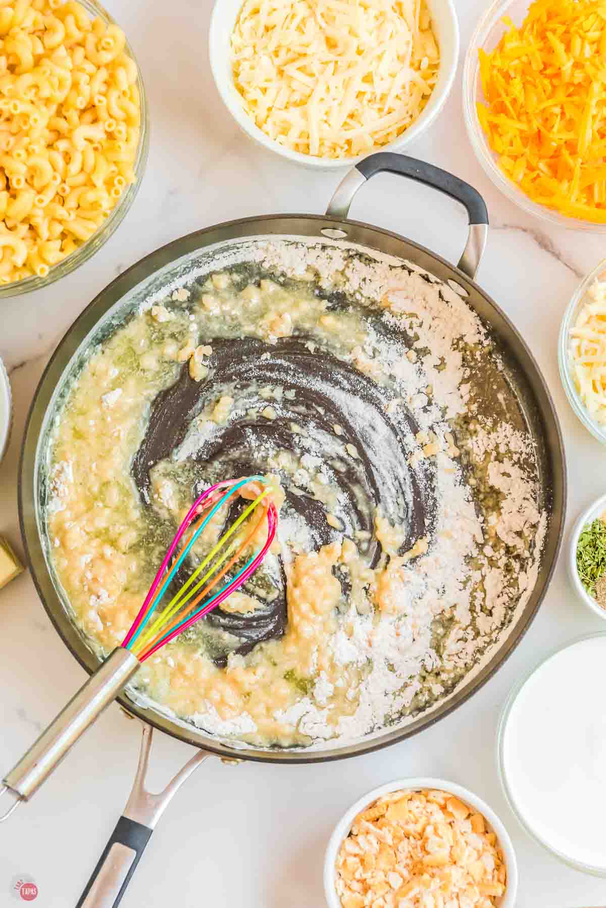 skillet with a wood spoon stirring flour and butter to make a roux