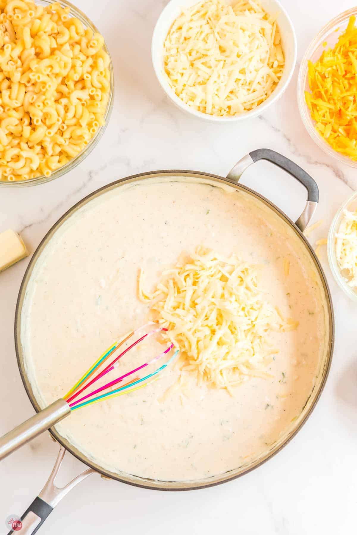 shredded cheese sprinkled in a skillet with a cream sauce