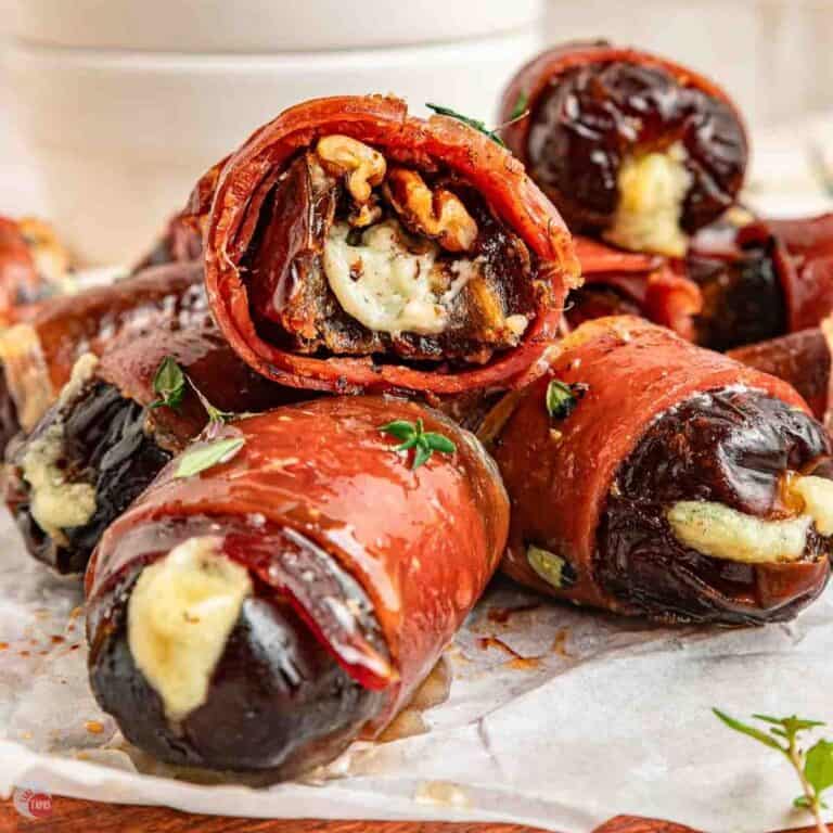 a prosciutto wrapped date cut open to show the blue cheese and nut inside