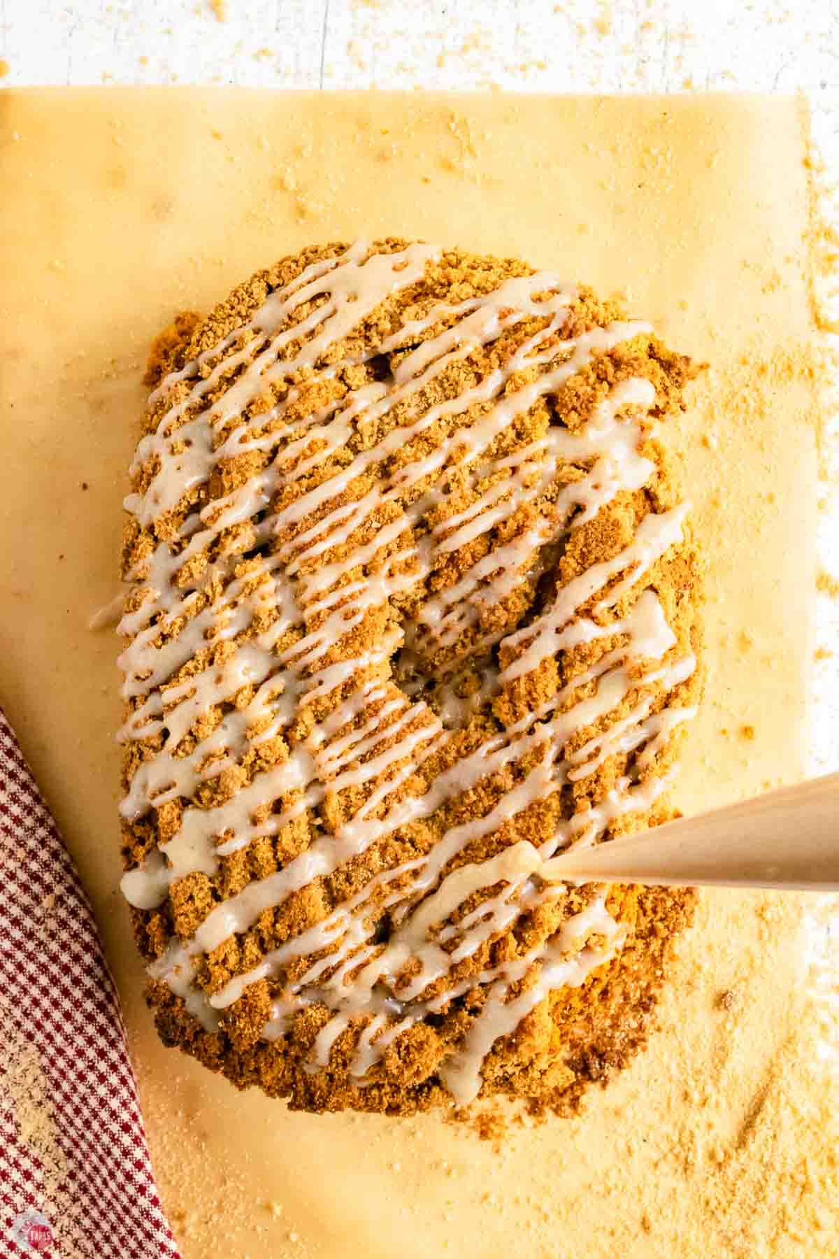 cream cheese glaze being drizzled over a loaf of bread