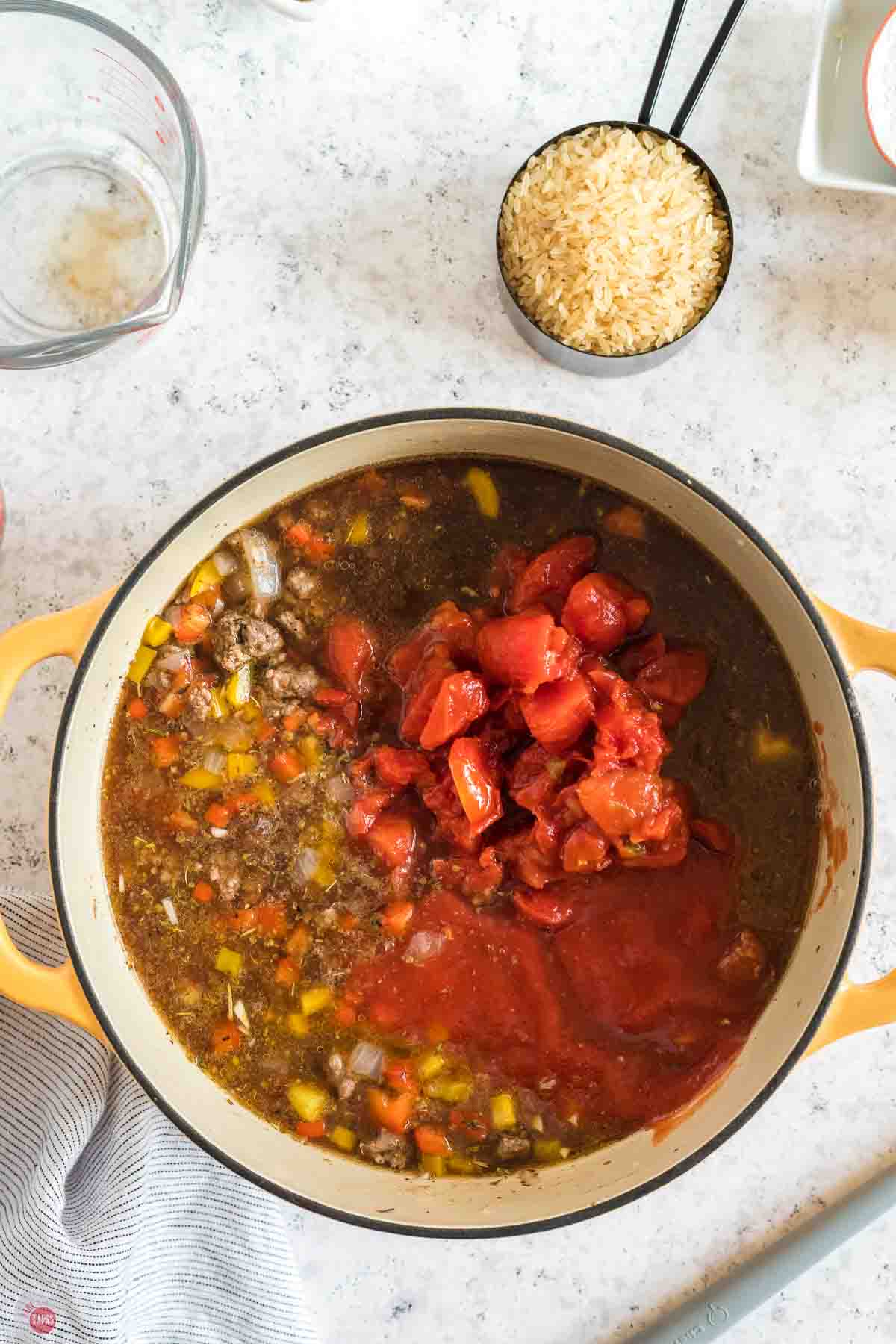 pot with broth, tomatoes, and cooked ground beef and peppers