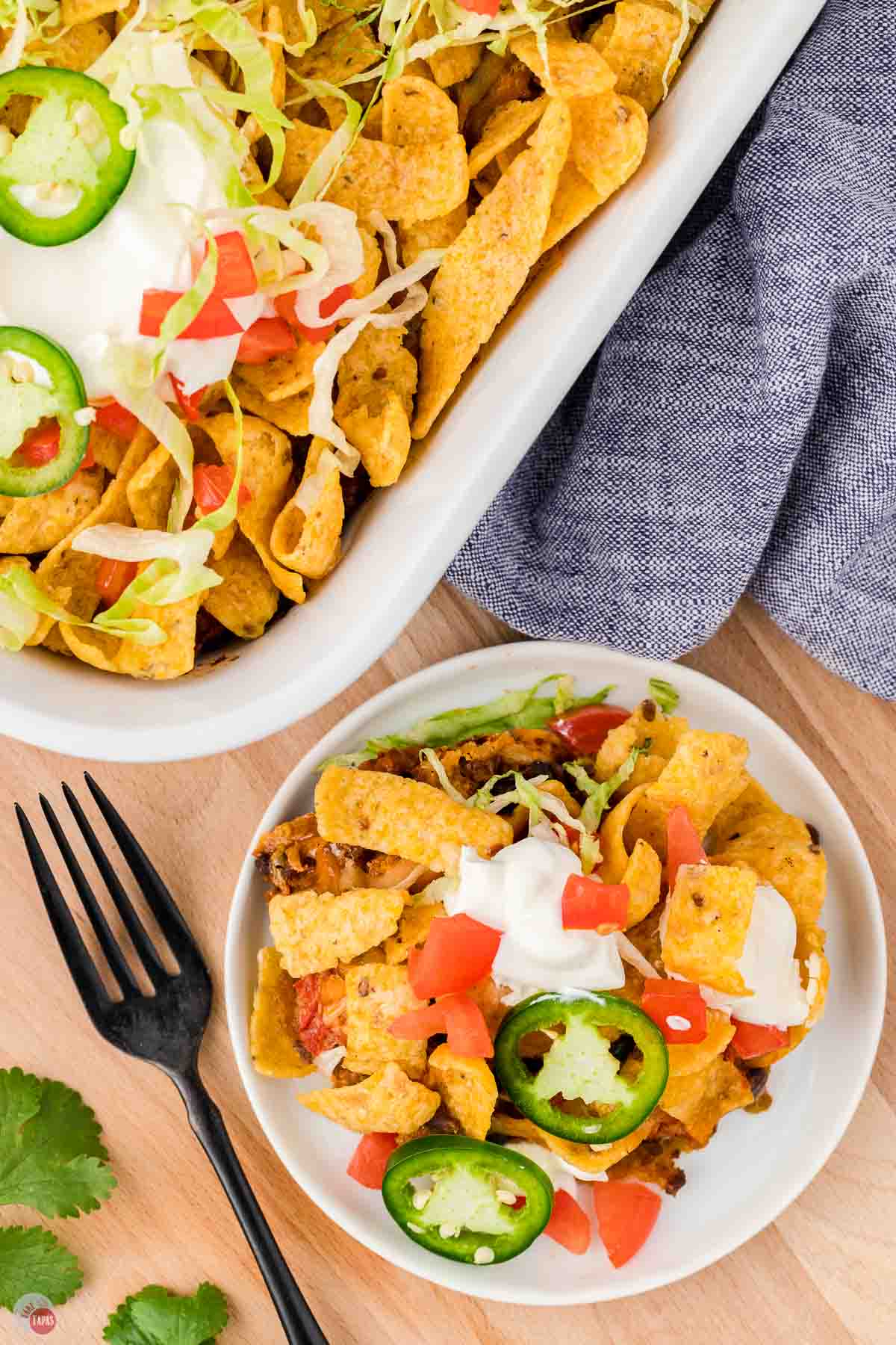 overhead of plate of walking taco casserole next to a full dish
