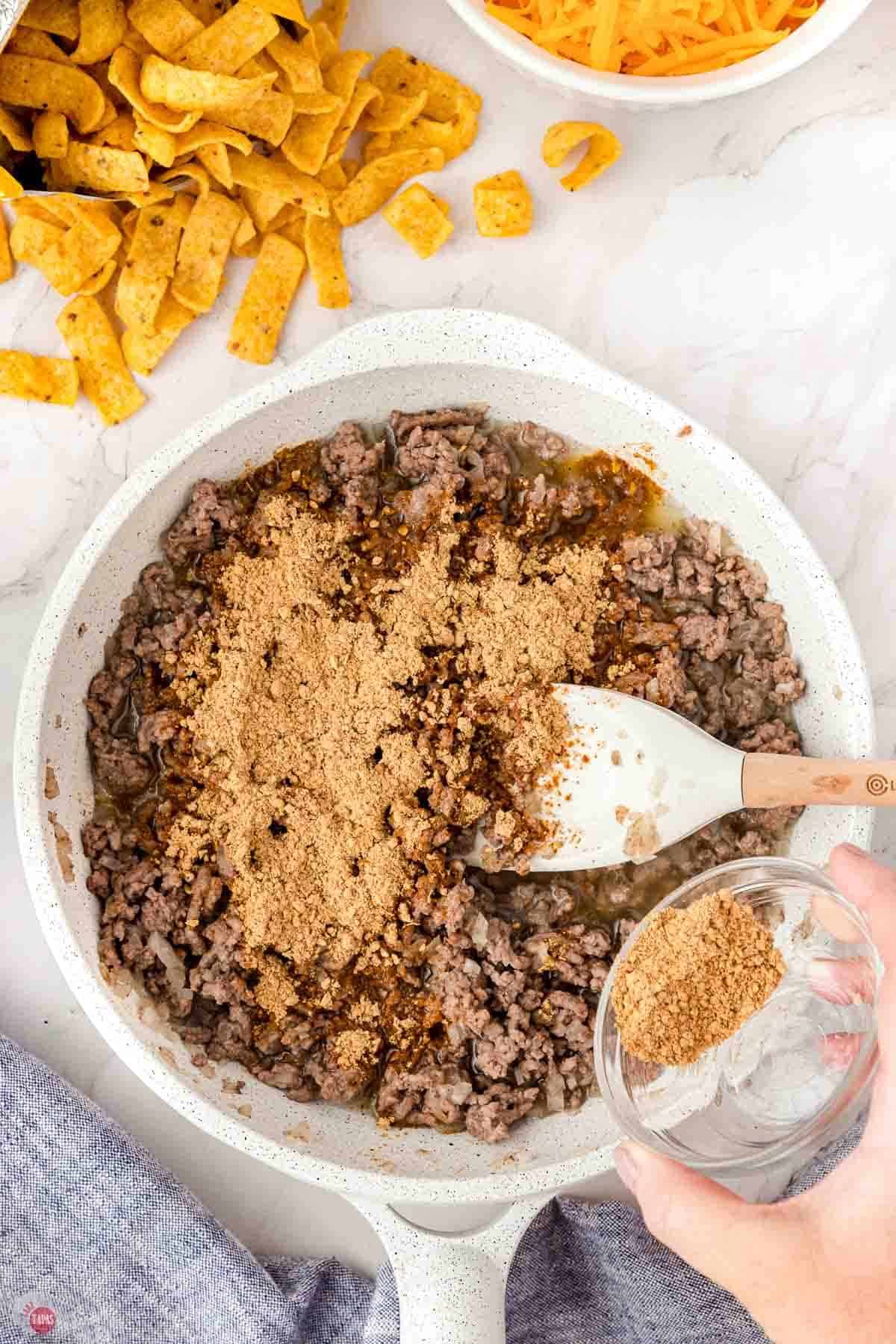 ground beef and taco seasoning cooking with water in a skillet